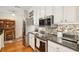 Modern kitchen with stainless steel appliances, dark countertops, mosaic tile backsplash, and wooden floors at 145 Pier View St # 316, Charleston, SC 29492
