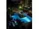 Nighttime view of a beautifully lit community pool surrounded by lush landscaping and relaxing lounge area at 145 Pier View St # 316, Charleston, SC 29492