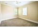 Cozy bedroom featuring neutral carpeting, ceiling fan, and natural light from two bright windows at 1717 Rivertowne Country Club Dr, Mount Pleasant, SC 29466
