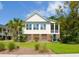 Inviting two-story home featuring well-manicured lawn, tall palm trees, and a lovely screened-in porch at 1717 Rivertowne Country Club Dr, Mount Pleasant, SC 29466