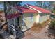 Charming home exterior features a striking red roof, complementing the light yellow siding and covered porch at 221 Church St, Mount Pleasant, SC 29464
