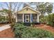 Charming cottage-style home featuring a screened porch and beautifully landscaped front yard with brick walkway at 221 Church St, Mount Pleasant, SC 29464