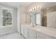 Bathroom featuring white vanity, large mirror with decorative lighting, and shower with glass door at 232 Haddrell St, Mount Pleasant, SC 29464