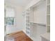Walk-in closet with built-in shelving and ample storage space, complemented by hardwood floors and natural light at 232 Haddrell St, Mount Pleasant, SC 29464
