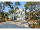 Charming coastal home with lush trees, a two-car garage and sun-drenched driveway at 232 Haddrell St, Mount Pleasant, SC 29464