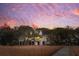 Charming home exterior featuring a wooden dock, marsh grasses, and mature trees at sunset at 232 Haddrell St, Mount Pleasant, SC 29464