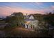 Two-story home with a chimney and lots of mature trees against a colorful sunset at 232 Haddrell St, Mount Pleasant, SC 29464