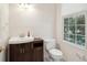 Cozy powder room with wood vanity, white fixtures, and natural light from the window at 232 Haddrell St, Mount Pleasant, SC 29464