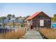Quaint waterfront shed with dock and American flag, providing a unique coastal retreat at 232 Haddrell St, Mount Pleasant, SC 29464