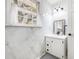 Bright bathroom features white marble walls, a modern vanity, and natural light from the window at 24 N Basilica Ave, Hanahan, SC 29410