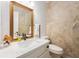 Bathroom with large mirror, stone walls, and decorative flower at 24 N Basilica Ave, Hanahan, SC 29410