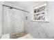 Bright bathroom features a stone-tiled shower with white marble walls and a window for natural light at 24 N Basilica Ave, Hanahan, SC 29410