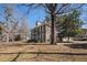 Two-story brick home with mature trees, balcony, and a lush lawn surrounding the property at 24 N Basilica Ave, Hanahan, SC 29410