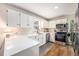 Bright kitchen features white cabinets, stainless steel appliances, quartz counters, and wood flooring at 24 N Basilica Ave, Hanahan, SC 29410