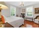 Bright bedroom featuring hardwood floors, two windows, neutral walls, and a comfortable bed at 26 Beverly Rd, Charleston, SC 29407