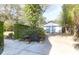 A two car garage sits at the end of a driveway, surrounded by plants and mature trees at 26 Beverly Rd, Charleston, SC 29407