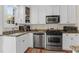 Well-lit kitchen featuring granite countertops, stainless steel appliances, and classic white cabinetry at 26 Beverly Rd, Charleston, SC 29407