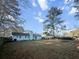 Spacious backyard featuring a large lawn, mature trees, and a charming light blue house exterior at 2929 Salamander Creek Ln, North Charleston, SC 29406