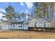 Charming single-story home with a well-manicured lawn, blue and brick exterior, and mature trees at 2929 Salamander Creek Ln, North Charleston, SC 29406
