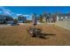 Back yard featuring a black metal table and chairs set with an umbrella under a bright blue sky at 317 Catawba Branch Way, Moncks Corner, SC 29461