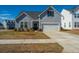 Charming gray two-story home featuring an attached garage and professionally landscaped front yard at 317 Catawba Branch Way, Moncks Corner, SC 29461