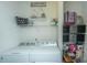 Well-organized laundry room with washer, dryer, shelving and storage baskets for supplies at 317 Catawba Branch Way, Moncks Corner, SC 29461