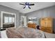 Bedroom with a ceiling fan, large mirror, open doorway to another room and brown dresser at 3334 Cottonfield Dr, Mount Pleasant, SC 29466