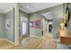 Well-lit hallway with hardwood floors, stylish artwork, and access to a bathroom and laundry area at 3334 Cottonfield Dr, Mount Pleasant, SC 29466
