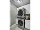 Laundry room with a stacked washer and dryer, white cabinets, gray walls and tile floors at 3334 Cottonfield Dr, Mount Pleasant, SC 29466