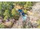 An aerial view shows a home with a pool, nestled in a wooded lot, creating a private retreat at 405 Huntington Rd, Summerville, SC 29483