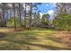 Expansive backyard view of a two-story brick home with a screened porch and ample green space at 405 Huntington Rd, Summerville, SC 29483