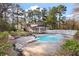 Backyard with an in-ground pool, surrounded by trees and a fence, with a home in the background at 405 Huntington Rd, Summerville, SC 29483