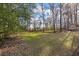 Large, green backyard, partially wooded, with an outbuilding, offering privacy and space at 405 Huntington Rd, Summerville, SC 29483