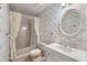 Vintage bathroom with floral wallpaper, shower-tub combination, and oval mirror above the sink at 405 Huntington Rd, Summerville, SC 29483