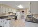 Efficient kitchen features white cabinets, tile floor and black appliances at 405 Huntington Rd, Summerville, SC 29483