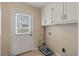 Utility room with tile floors, white cabinets, and access to the backyard at 405 Huntington Rd, Summerville, SC 29483