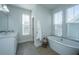 Bright bathroom features a tub, double windows, tiled floors and a sink with a vanity at 411 Watergrass Way, Summerville, SC 29485
