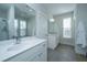 Bright bathroom features a double sink vanity, tiled floors, walk in shower and two windows at 411 Watergrass Way, Summerville, SC 29485