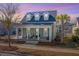 Charming home with inviting front porch, dormer windows and lush landscaping at 411 Watergrass Way, Summerville, SC 29485