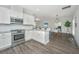 Modern kitchen with white cabinets, stainless steel appliances and a view into the dining and living area at 411 Watergrass Way, Summerville, SC 29485