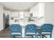 Bright, white kitchen features stainless steel appliances, subway tile backsplash and granite countertops with island seating at 411 Watergrass Way, Summerville, SC 29485
