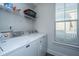 Functional laundry room with Maytag washer and dryer, shelving and a window for natural light at 411 Watergrass Way, Summerville, SC 29485
