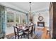 Dining room with wood table, chairs, chandelier, and large windows overlooking the porch at 4162 Ten Shillings Way, Hollywood, SC 29470