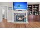 Living room featuring a stone fireplace, built-in bookcase, and hardwood floors at 4162 Ten Shillings Way, Hollywood, SC 29470
