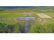 Aerial view showcasing the equestrian facilities and surrounding landscape with paddocks, barn, and training areas at 4385 Ten Shillings Way, Hollywood, SC 29470