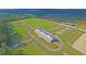 Aerial shot of a vast horse farm with multiple training arenas and barns under a sunny sky at 4385 Ten Shillings Way, Hollywood, SC 29470