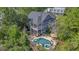 Picturesque aerial view of a blue house, nestled among lush greenery, featuring a pool, spa, and wooden walkway at 4385 Ten Shillings Way, Hollywood, SC 29470