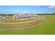 Drone shot of a horse barn with multiple stalls and green pastures under a bright, sunny sky at 4385 Ten Shillings Way, Hollywood, SC 29470
