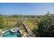 Lush backyard featuring a pool and a dock leading to the waterway at 4385 Ten Shillings Way, Hollywood, SC 29470