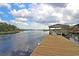 Wooden dock extending into a tranquil river beneath a partly cloudy sky, with trees lining the distant shore at 4385 Ten Shillings Way, Hollywood, SC 29470